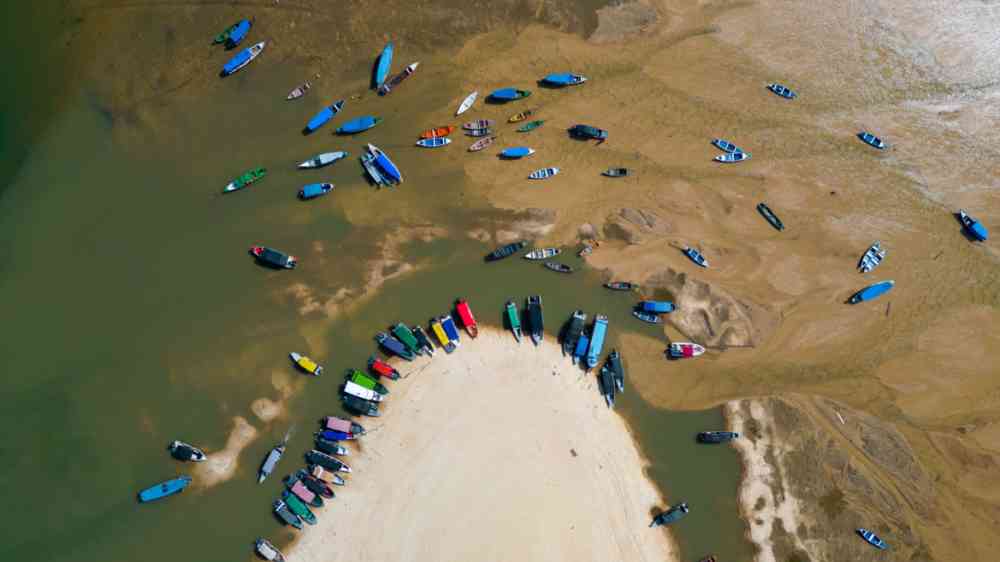 Small boats stranded in the nearly dry bed of the Tapajos river in Alter do Chao, Santarem, Brazil, during the amazonian drought in the second half of 2023