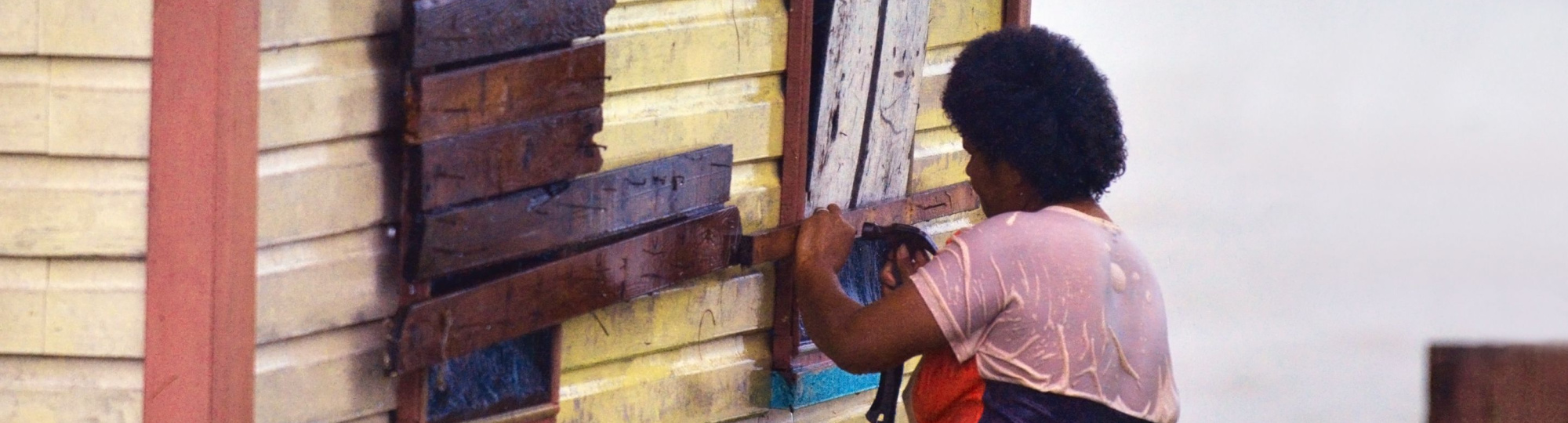 Fijian woman boarding up her house during tropical cyclone Winston in 2016.