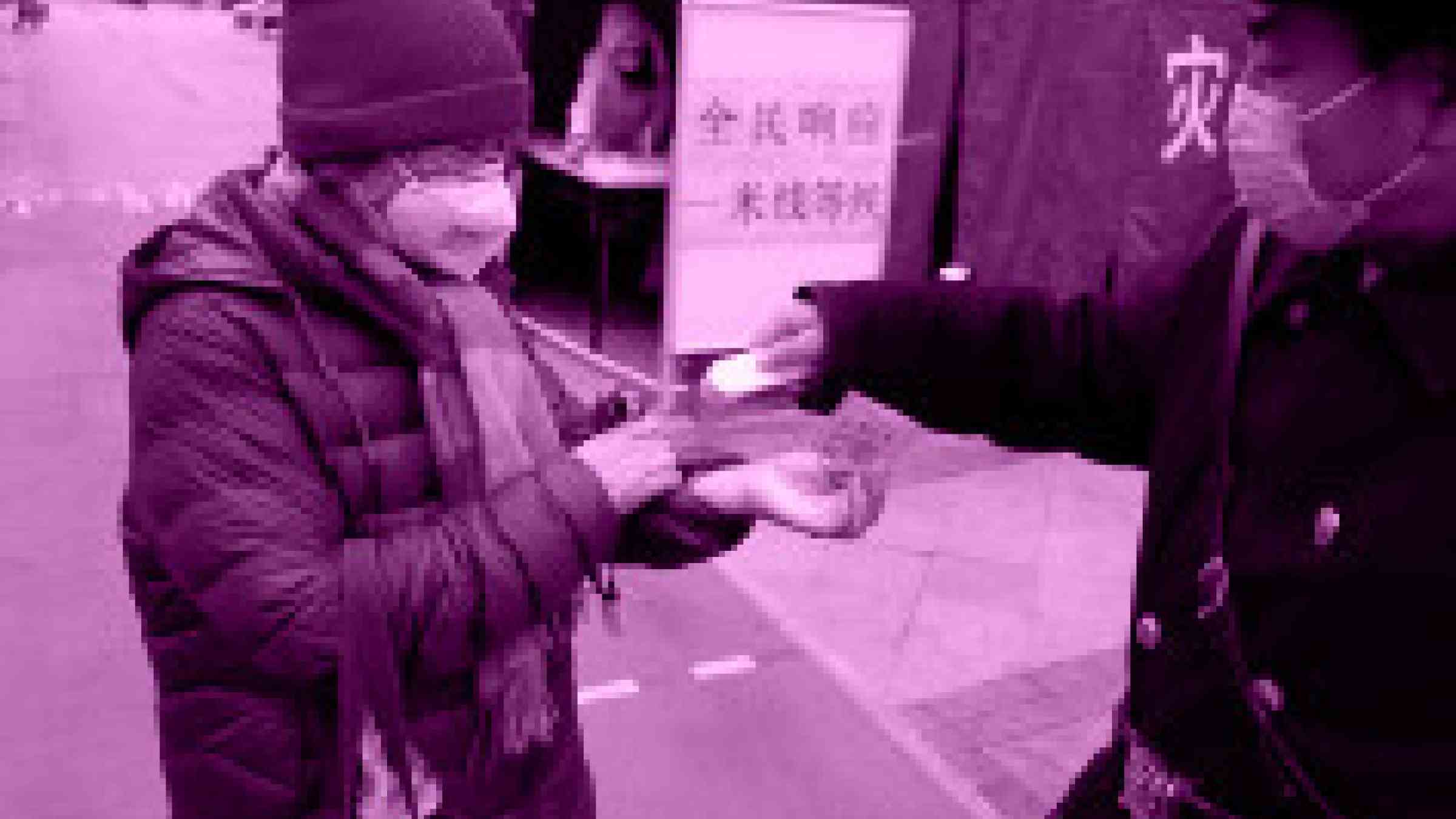 A man giving hand sanitiser to another man in a street in China