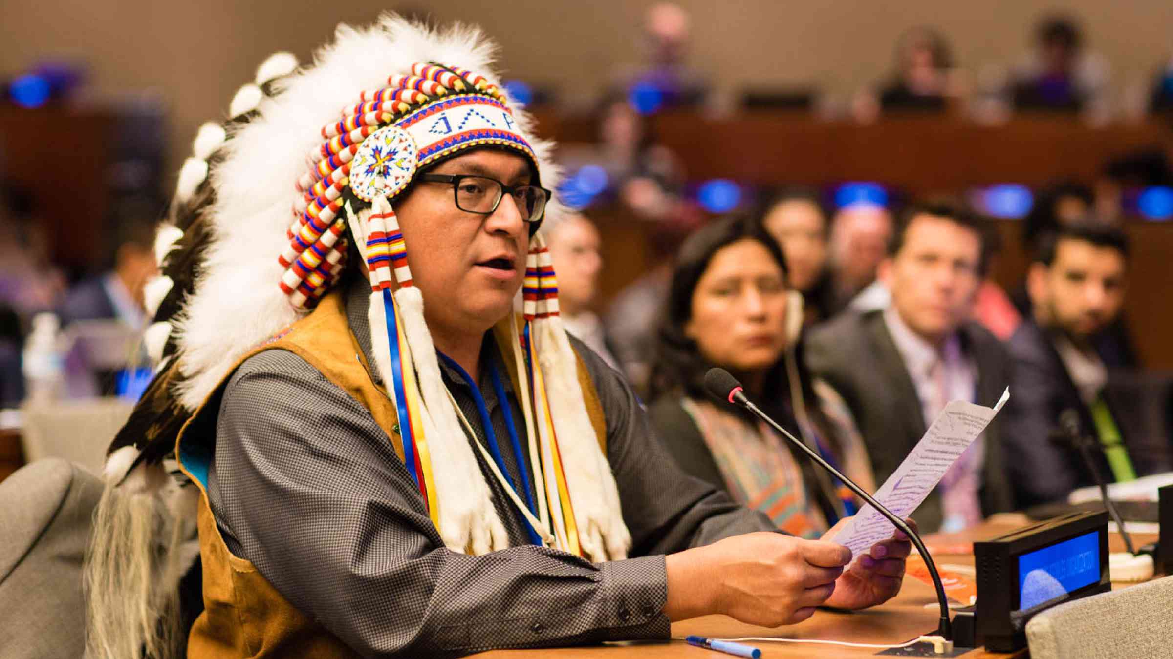 Group of people at the UN meeting including a Native American Indigenous Speaker
