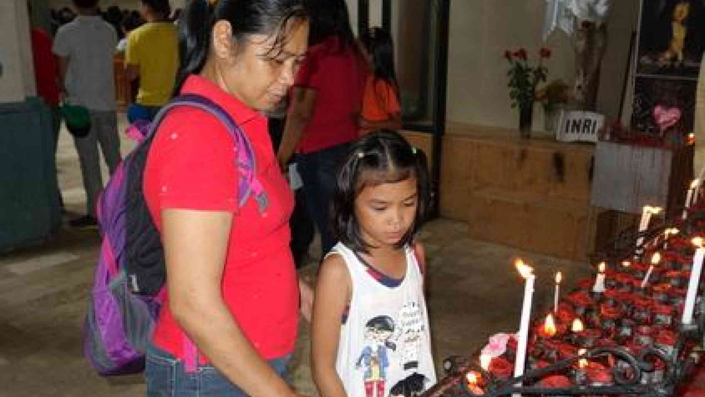 Yesterday was a day of remembrance in Tacloban; 30 days after Typhoon Haiyan a mother and her daughter light candles for those who did not survive the super typhoon.