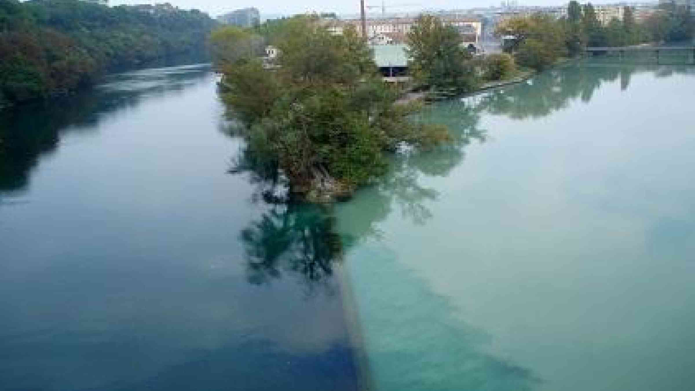 The sediment-heavy River Arve flows into the River Rhone in Geneva